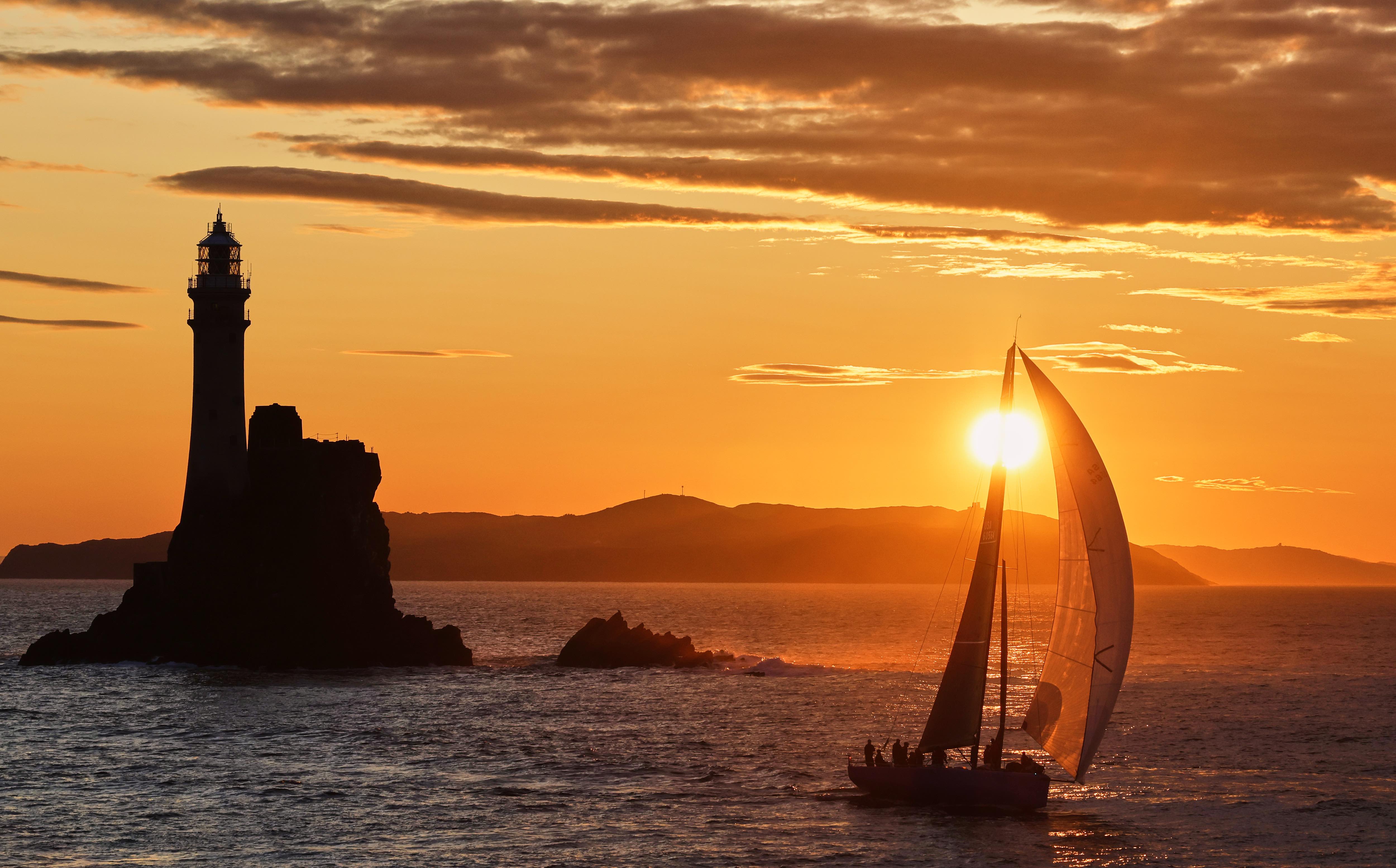 Chris Sheehan's PAC 52 Warrior Won rounds the Fastnet Rock at dawn this morning © ROLEX/Carlo Borlenghi